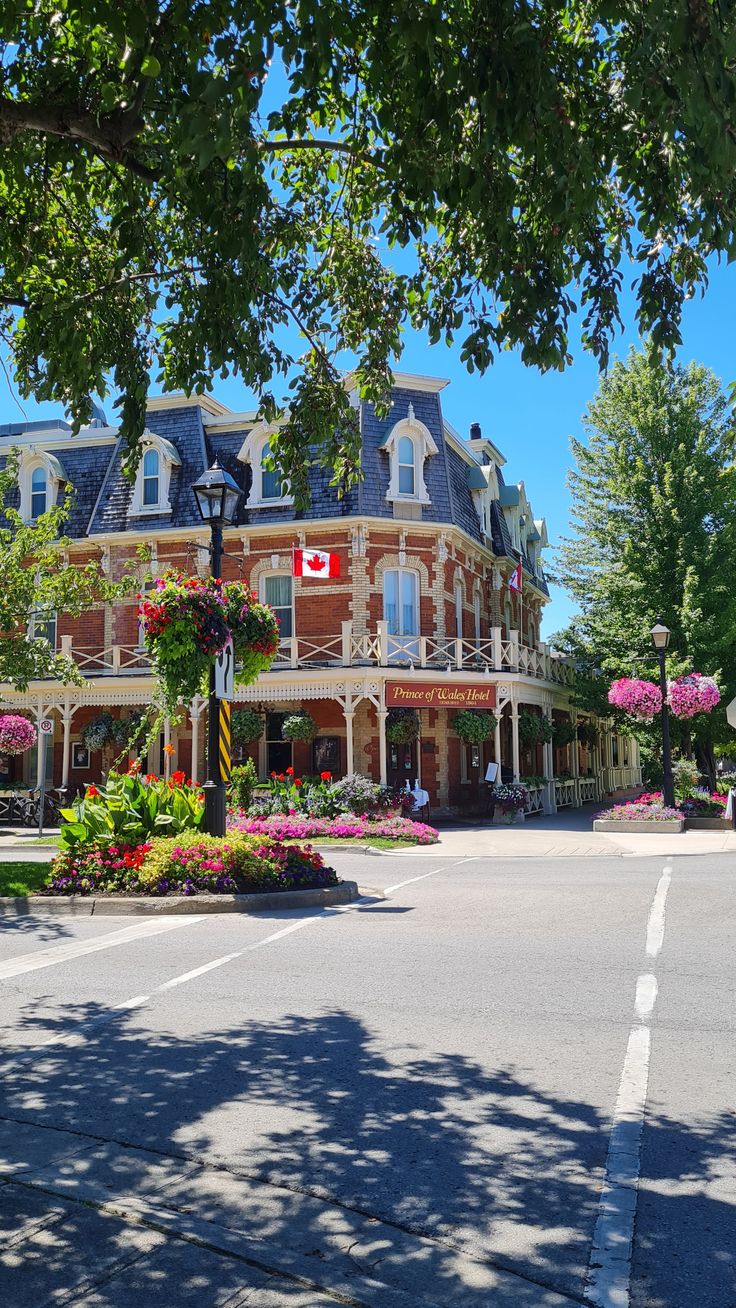 Street view of Prince of wales hotel at niagara on the lake with flowers and trees around it.